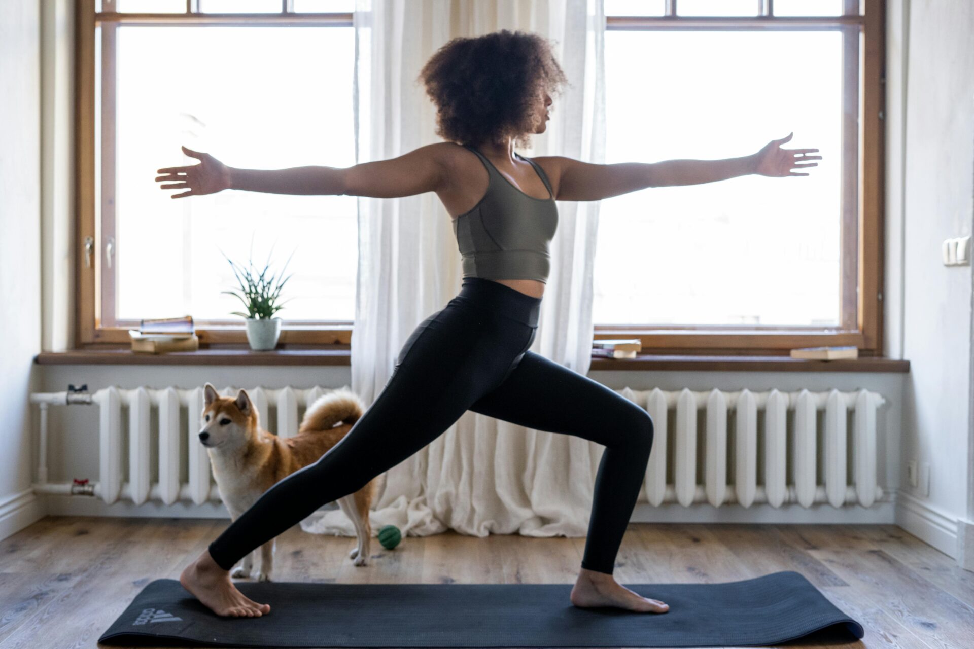 Fit woman working out in living room on yoga mat