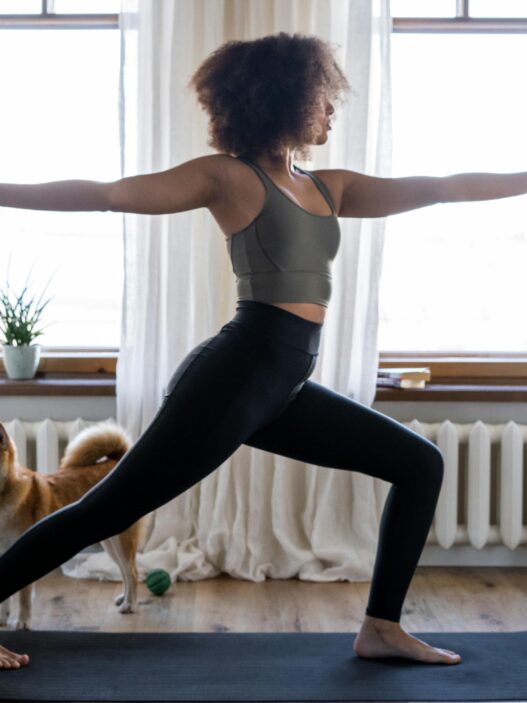 Fit woman working out in living room on yoga mat