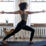 Fit woman working out in living room on yoga mat