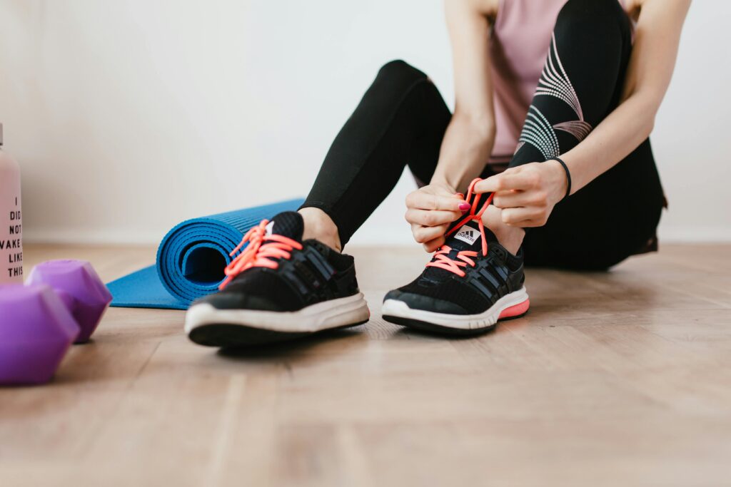 Woman working out at home putting her shoes on 